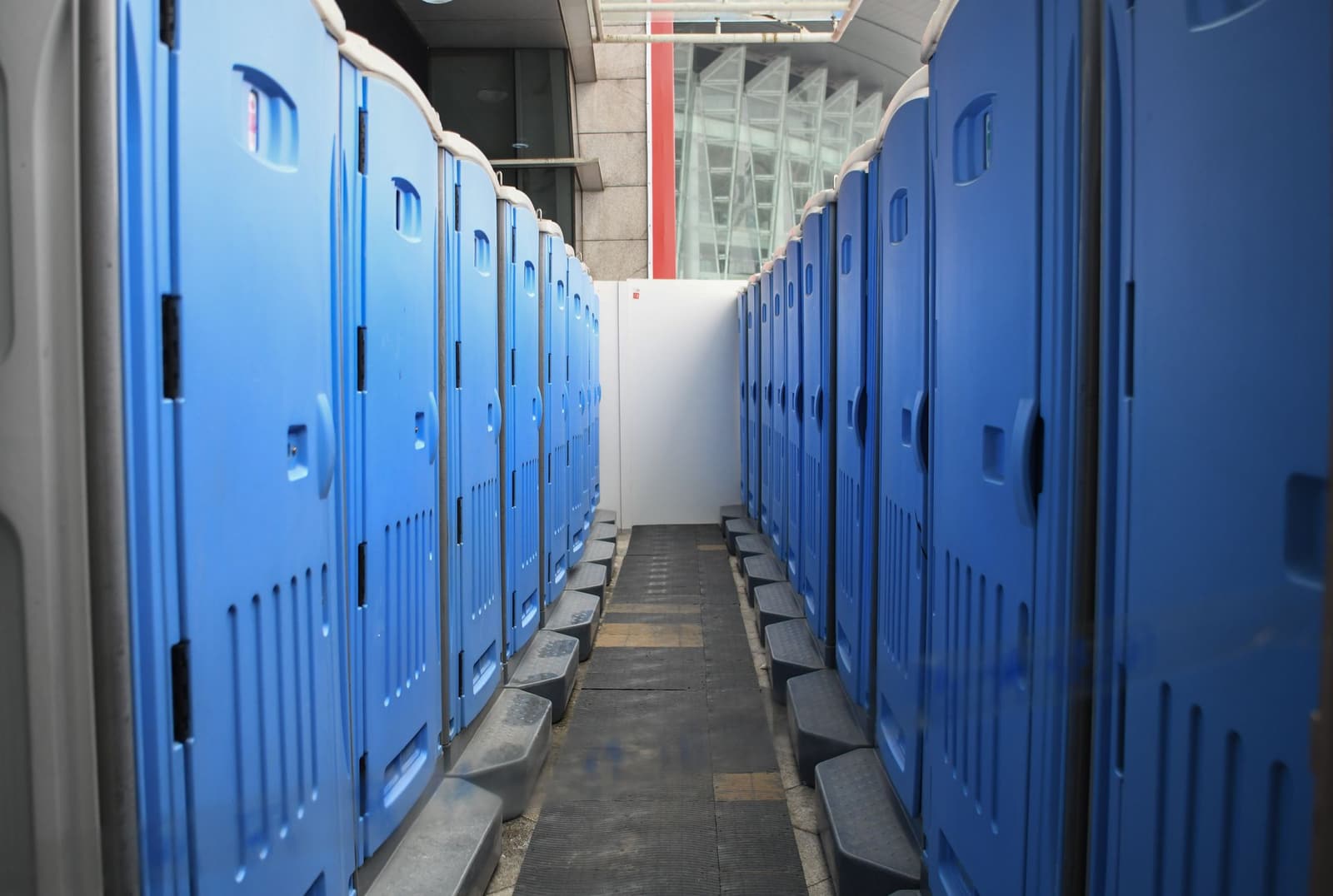 Portable restrooms lined up along the edge of an active construction site