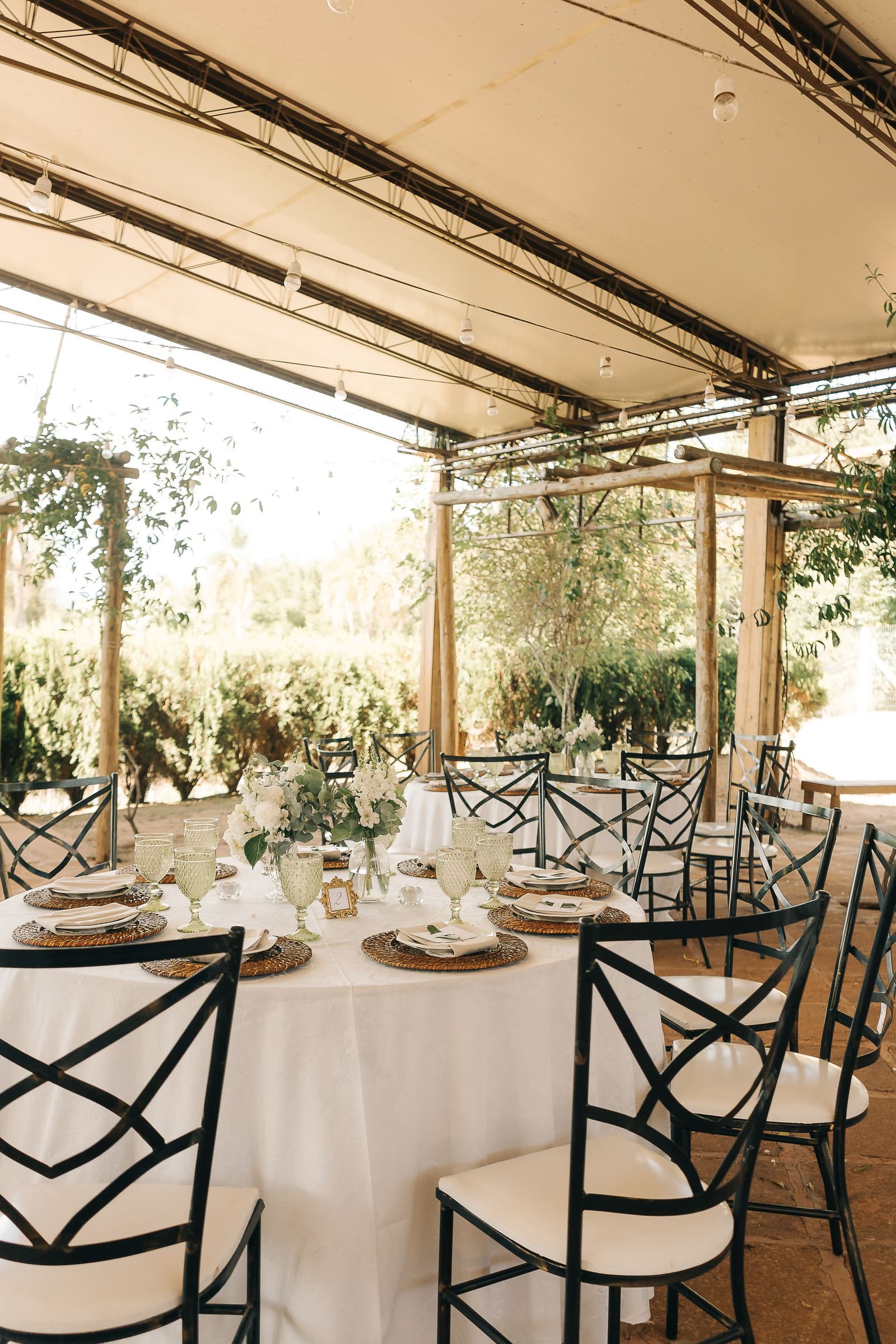 Elegant outdoor wedding reception table setting under a marquee